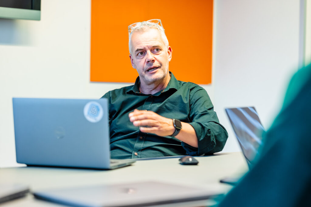 Office worker discussing with a colleague in front on their laptops