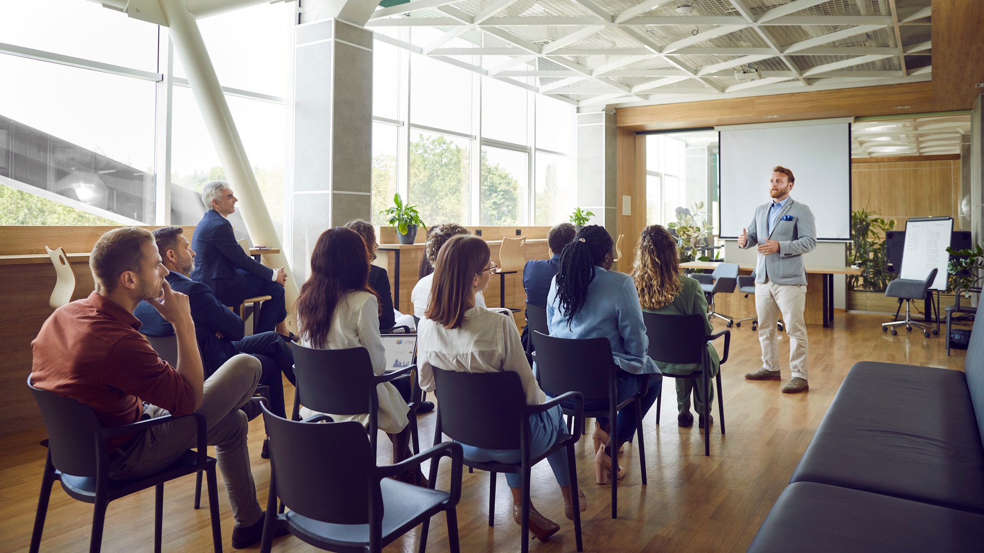 Trainer in front of 10 students in a business meeting room