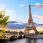Photo of the Eiffel Tower and of a bridge spanning over the Seine river in Paris, capital city of France