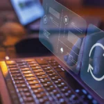 Update and maintenance icons virtually laid over a person typing on his laptop