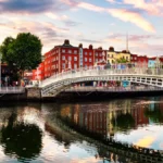 Evening view of the illuminated Ha’penny Bridge at sunset in Dublin, capital of Ireland
