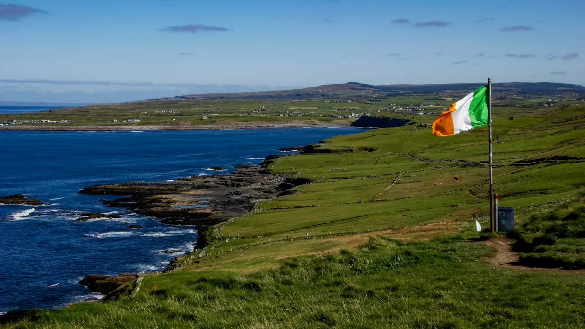 Irish flag waving in the wind in front of the rugged cliffs of the coastline in Ireland