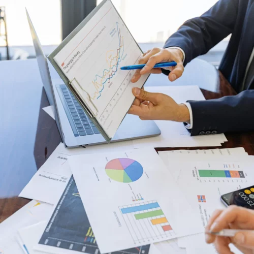 Colleague presenting figures and charts from a market report during a team discussion