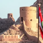 Mutrah Fort in Muscat, Sultanate of Oman, with the Omani flag displayed in the foreground.