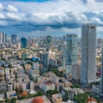 Modern high-rise residential apartment buildings lining Rothschild Boulevard in Tel Aviv, Israel, with balconies and dense urban architecture typical of the area.
