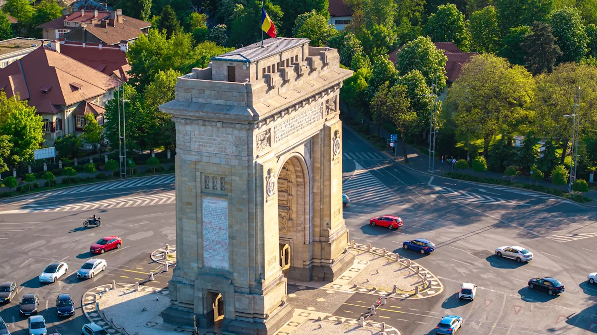 Arch of Triumph in Bucharest, Romania, surrounded by traffic and greenery along Kiseleff Boulevard.