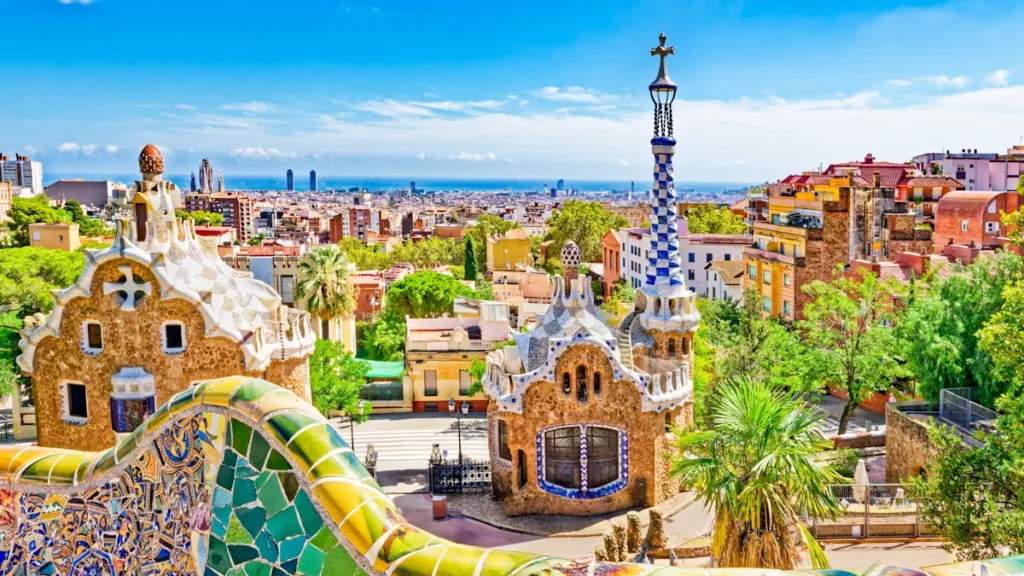 Panoramic view of Barcelona from Park Güell, featuring Gaudí’s colorful mosaic architecture and the city skyline.